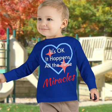 Rabbit Skins toddler long-sleeve t-shirt with “Miracles Happen” design and uplifting message, soft cotton, breathable and durable, Christian apparel for everyday wear and faith-filled gifting, todder boy in blue long-sleeve t-shirt